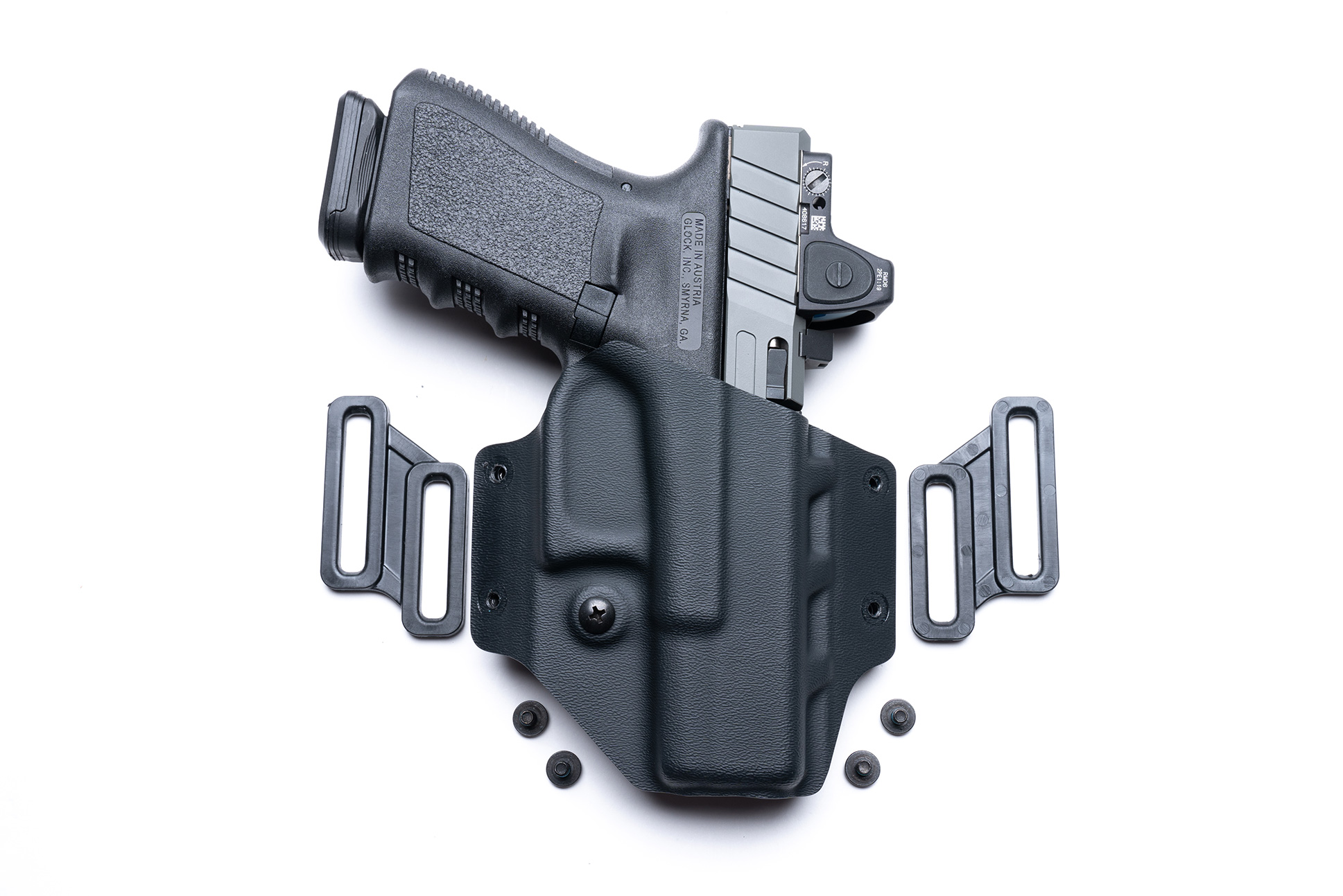 Covert OWB holster in black KYDEX with a pistol and adjustable belt loops for comfort and concealment.
